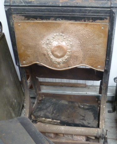 A Victorian cast iron fire place with embossed copper cowl.