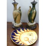 A pair of glazed china 'ewer' table lamps and a large Italian 'sun' platter.