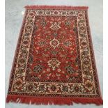 A red ground patterned woollen rug, 1.37 x 0.97m, and a pink ground floral patterned woollen rug,