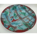 A large Poole Pottery charger from the Delphis range decorated with deep turquoise and burgundy
