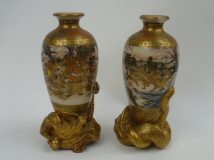 A pair of Japanese Satsuma vases decorated with warriors and fighting scenes each raised on