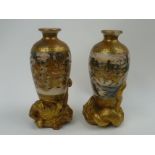A pair of Japanese Satsuma vases decorated with warriors and fighting scenes each raised on