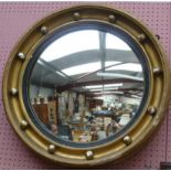 A Regency style gilt framed circular convex wall mirror with ball decoration.