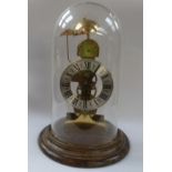A German Kieninger striking skeleton clock contained within a glass dome.