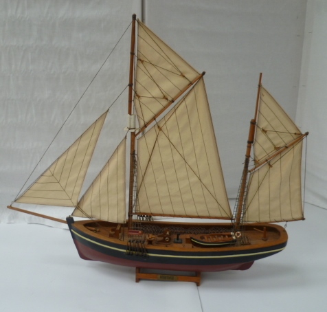 A wood model of a sailing Brixham trawler.