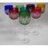 Eight overlaid coloured glass hock glasses each with different coloured overlay deeply etched with