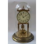 A two train cuckoo clock and a brass 400 day mantel clock contained within a glass dome.
