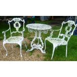 A white painted circular cast metal garden table with six chairs and a similar coffee table.
