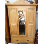 An Edwardian satin walnut single wardrobe with central mirrored door over a long drawer.
