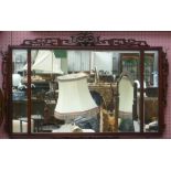 An Oriental hardwood framed rectangular wall mirror with carved and pierced decoration.