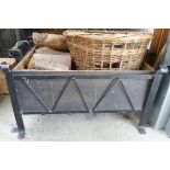 A rectangular wrought iron log basket with scrolling design and a wicker basket.