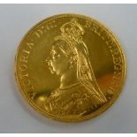 An 1887 gold five pound coin.