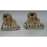 Two Basil Matthews Art pottery miniature figurines, each depicting a Pekinese dog on a blue and gilt