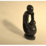 An African Verdite stylised carving of a mother lifting a child, signed Samson Mrewa.