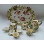 A Continental china floral encrusted tray and miniature tea set painted with floral sprays and