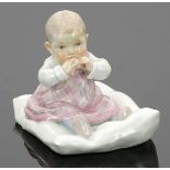 Kind, auf einem Kissen sitzendKönigliche Porzellan Manufaktur, Meissen 1905. Porzellan, weiß,