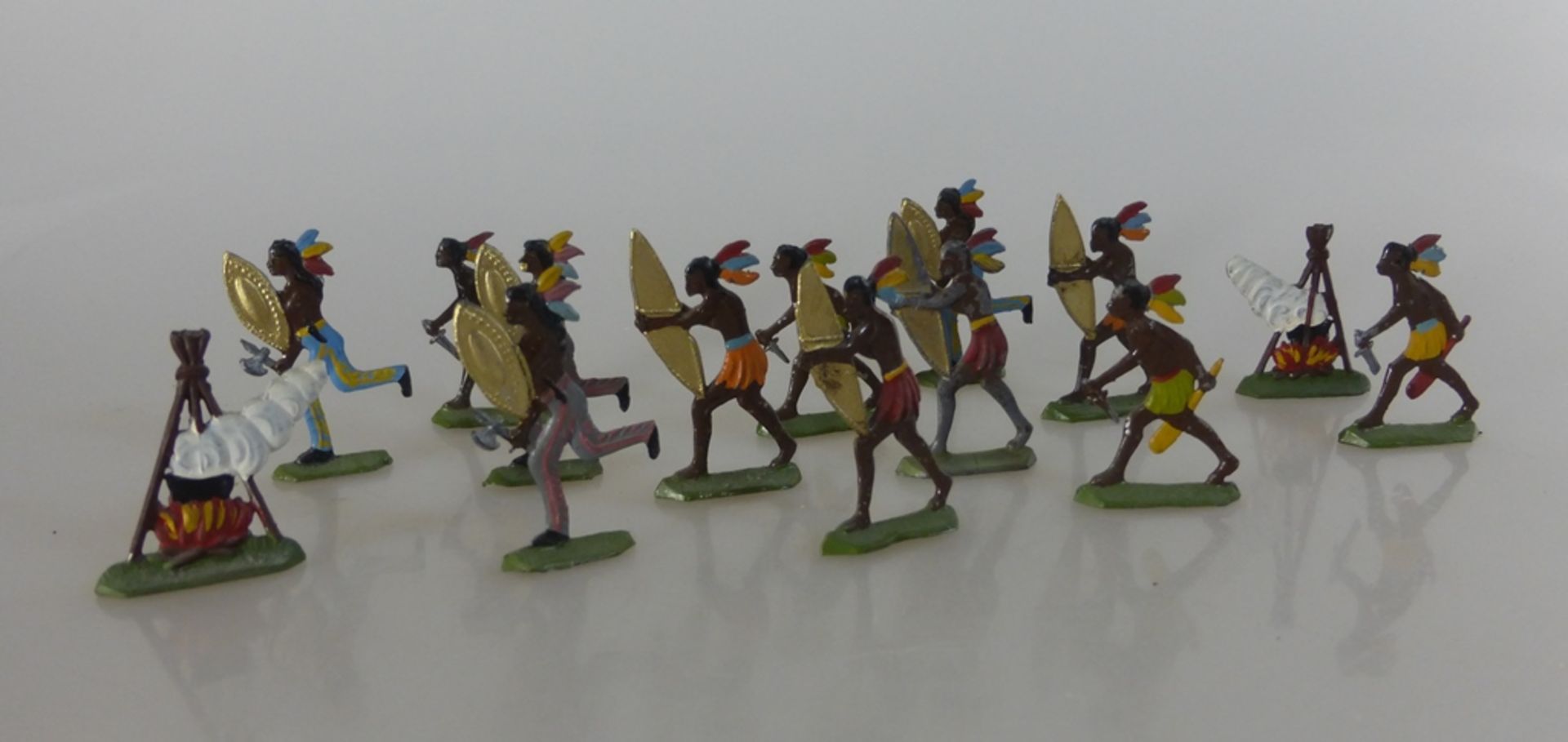 Konvolut Zinnfiguren, 12 Indianer im Kampf mit zwei Feuerstellen, h. 4cm, Vorkrieg