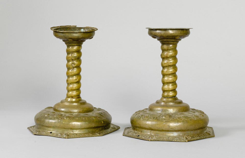 PAIR OF CANDLESTICKS, Baroque, 18th century. Chased brass. Cylindrical shaft. On a broad round