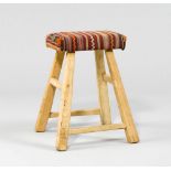 STOOL, in the rustic style. Wood. Rectangular, padded seat on inclined legs. Kilim cover.    HOCKER,