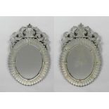 PAIR OF OVAL MIRRORS, Baroque style, Murano, 20th century. With a pierced volute top. H 100 cm.