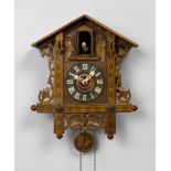 CUCKOO CLOCK, Black Forest, ca. 1900. Pinewood. Case designed as a house with pierced tendrils.