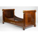 BED, Empire, France. Mahogany, partly ebonized and decorated with brass and bronze leaf volutes,