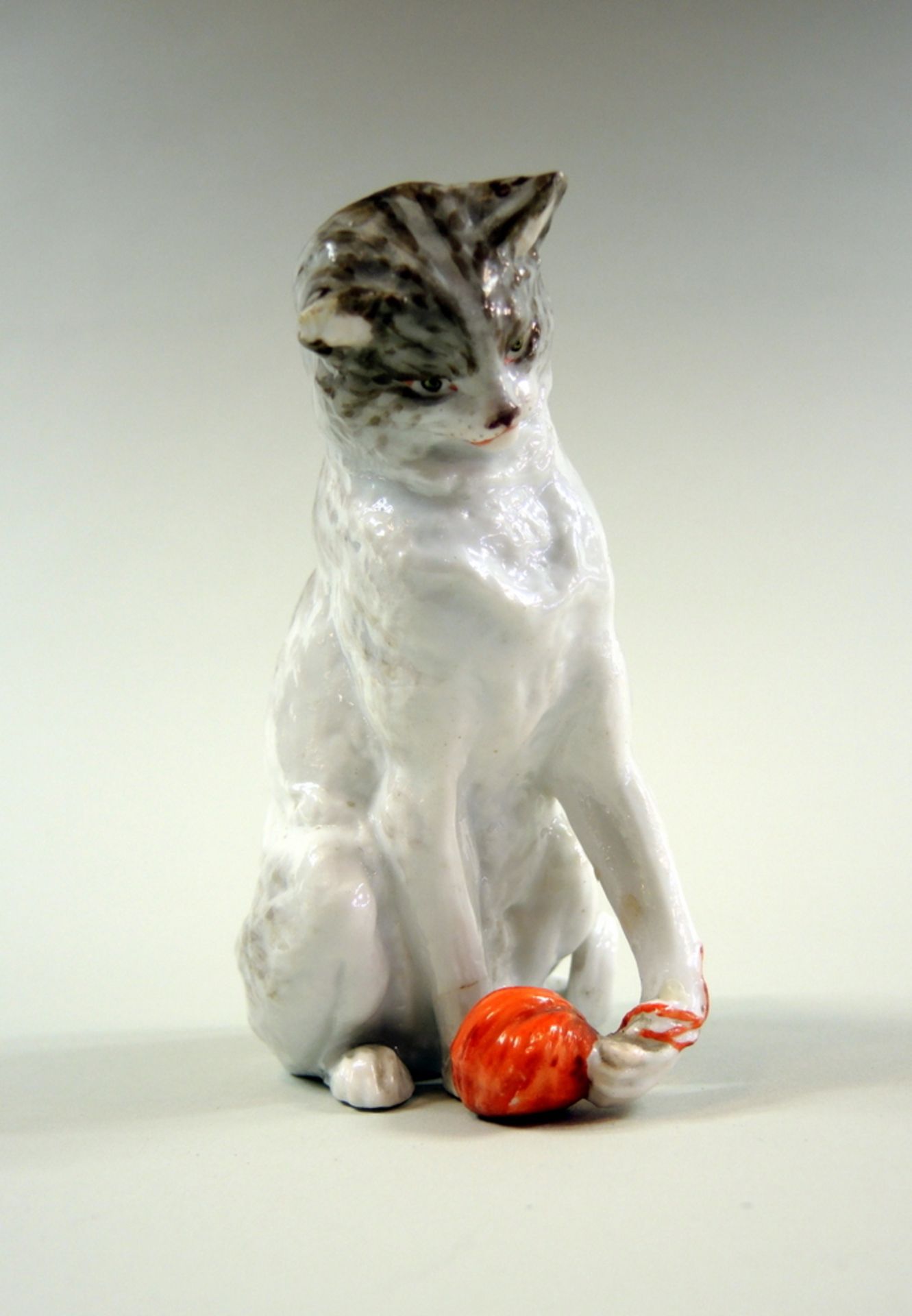 Kleine Porzellanfigur, Katze mit WollknäuelKleine Porzellanfigur, Katze mit Wollknäuel, polychrom