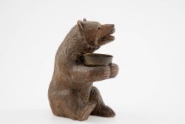 Sitzender Bär Holz vollrund geschnitzt. Auf dem Hinterteil sitzender Bär in den Pfoten eine kleine