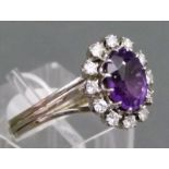 Damenring
14 kt. Weißgold, 1 ovaler Amethyst, Kranz mit 12 Brillanten, zusammen 
 ca. 0,45 ct.,