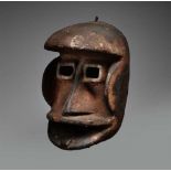 A GUERE MASK  With pierced rectangular eyes below the projecting forehead, carved tongue in relief