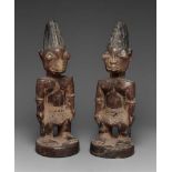 Yoruba ibeji couple  Ibeji, male, each with tall incised and blackened coiffure, carved teeth,