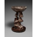 A YORUBA IFA BOWL  Agere ifa, the support carved as a kneeling female figure holding a child on