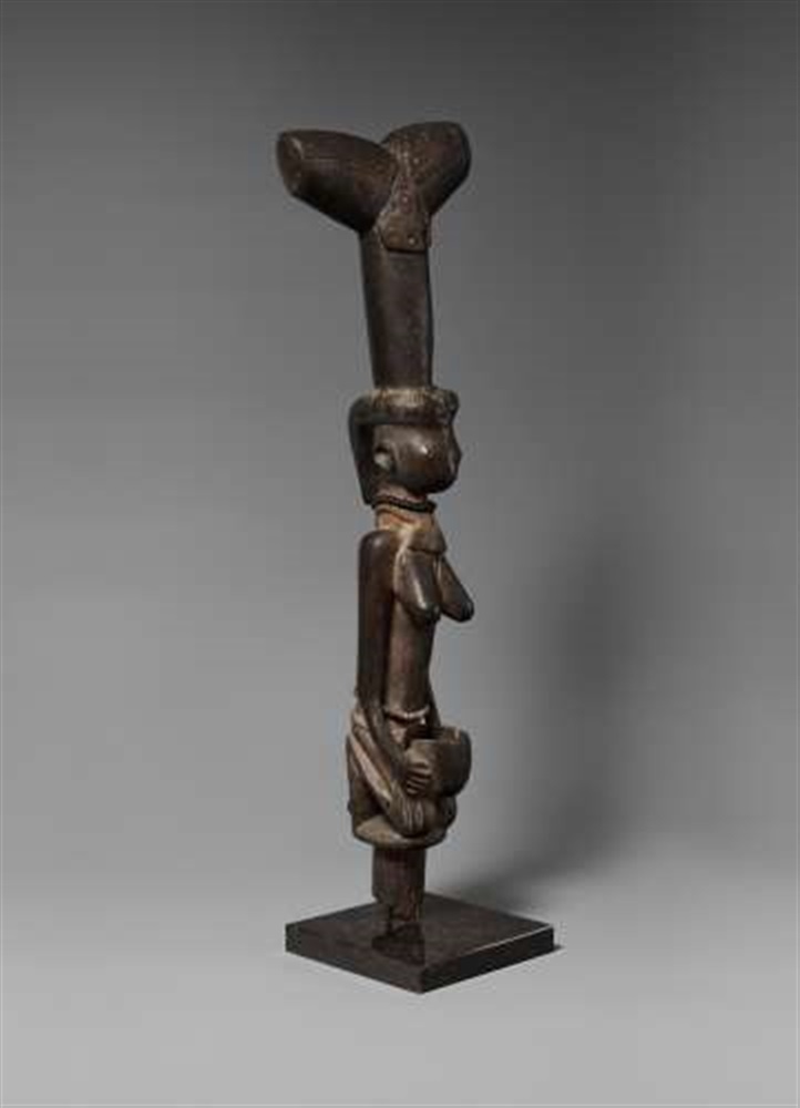 A YORUBA STAFF FOR SHANGO  Oshe Shango, carved as a kneeling female figure of elongated form holding