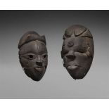TWO OGONI MASKS  Each with articulated lower jaw with inset wood teeth and black encrusted patina.