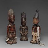 THREE YORUBA MALE TWIN FIGURES  One with lobed and incised coiffure, cowries and metal ornaments