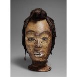 AN EKOI SKIN-COVERED HEADDRESS  With carved and whitened teeth in the open mouth, the head inset