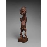 MBALA OR SUKU MALE FIGURE  Standing with one hand held forward, the other missing, the large head