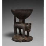A YORUBA IFA BOWL  Agere ifa, the support carved as a leopard with incised spots, dark patina. 18