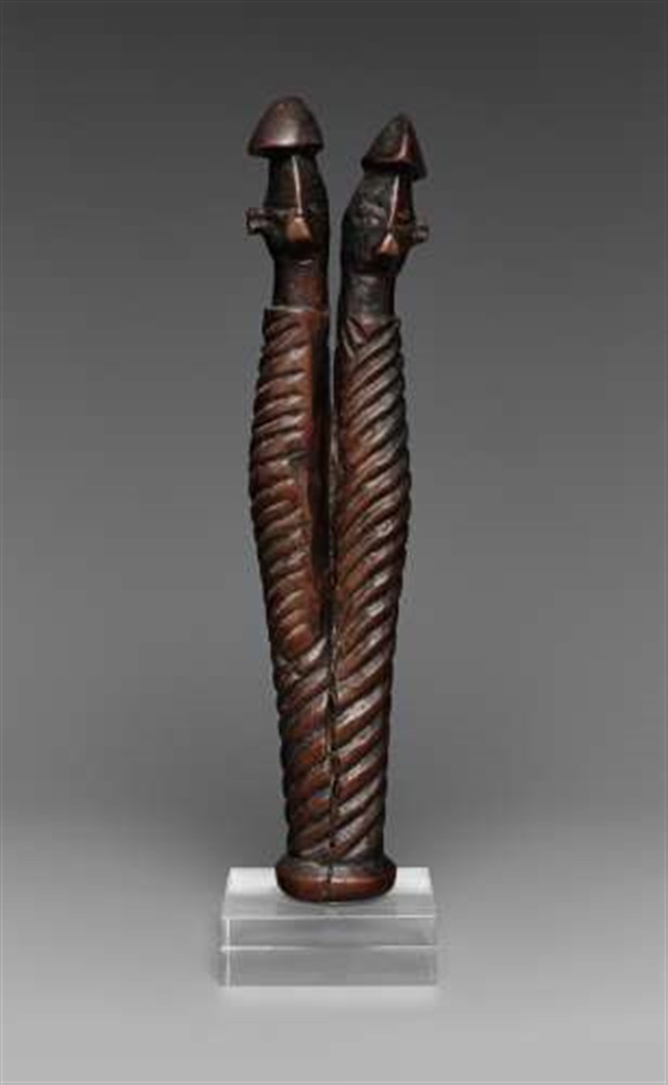 A YAKA CHARM FIGURE  Mbwoolo, the spirally carved forked body terminating in two heads, each with