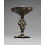 A YORUBA BRONZE RITUAL VESSEL The shallow circular bowl with cast loops about the border, the