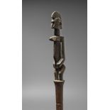 A BAMBARA STAFF Surmounted by a standing female figure with prominent breasts and scarified body,