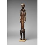 A TANZANIA FEMALE FIGURE With long torse and articulated arms, carved sex on the bulbous abdomen,