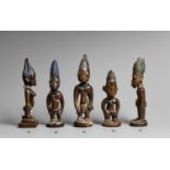 A YORUBA FEMALE TWIN FIGURE With tall conical bi-lobed coiffure, carved lip plug, beads about