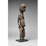 A LOBI FIGURE Standing with the arms free of the body, tall domed head with features in high relief,
