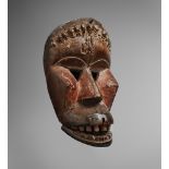 A KRAN MASK With pierced triangular eyes and angular cheeks, the domed forehead with carved band