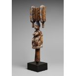 A YORUBA STAFF FOR SHANGO Oshe Shango, carved as a kneeling female figure holding a sash about her