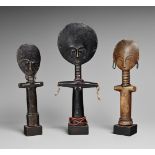 THREE ASHANTI DOLLS Akua ‘ba, each with the features in relief on the flat oval face, ringed