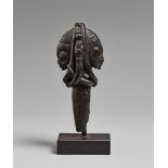 A YORUBA HANDLE OR FINIAL Carved as two addorsed heads with with finely notched coiffures linked