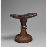 A LUBA HEADREST The slightly curved and waisted top on tapered base with three flanges at the