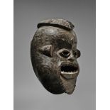 A GRASSLANDS CAMEROON MASK The large rectangular open mouth with carved teeth, pierced eyes, the